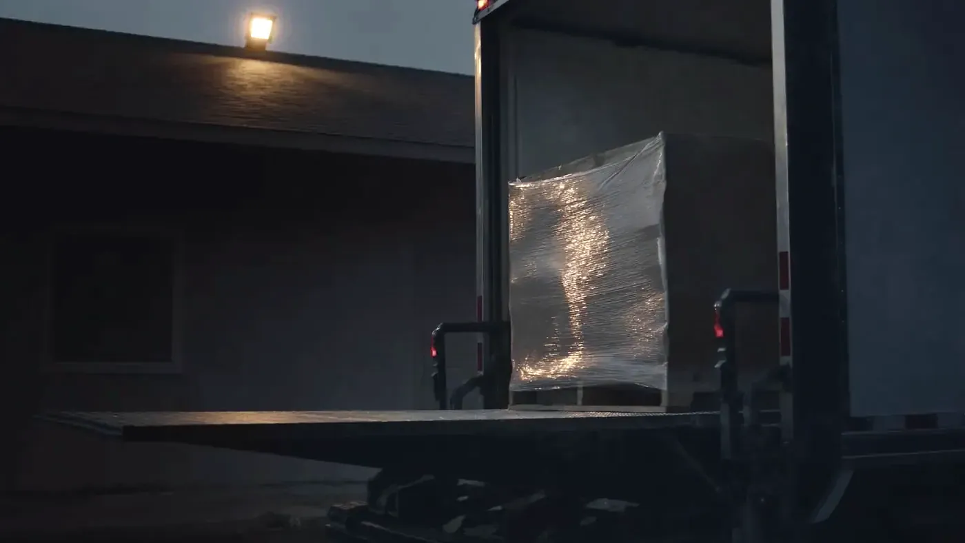 A pallet positioned on a truck tailgate for ground-level unloading